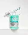 A mint-green Anua '100+' serum bottle with a silver label band reading 'PDRN + Hyaluron', standing on a white ledge with its silver dropper cap lifted out at an angle and drops falling, on a light grey background.