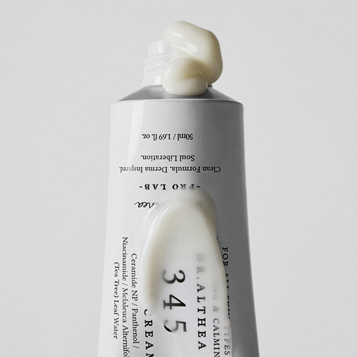 Primer plano de un tubo de Dr.Althea 345 boca abajo con un poco de crema blanca espesa saliendo de la boquilla y una pasada de crema sobre la etiqueta.
