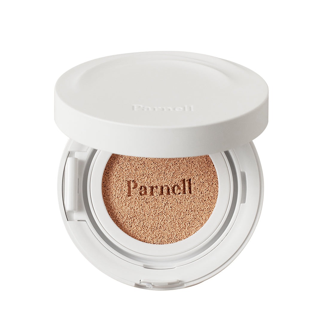 Open white Parnell cushion compact with the lid raised, showing a tan sponge embossed with the Parnell logo, on a white background.