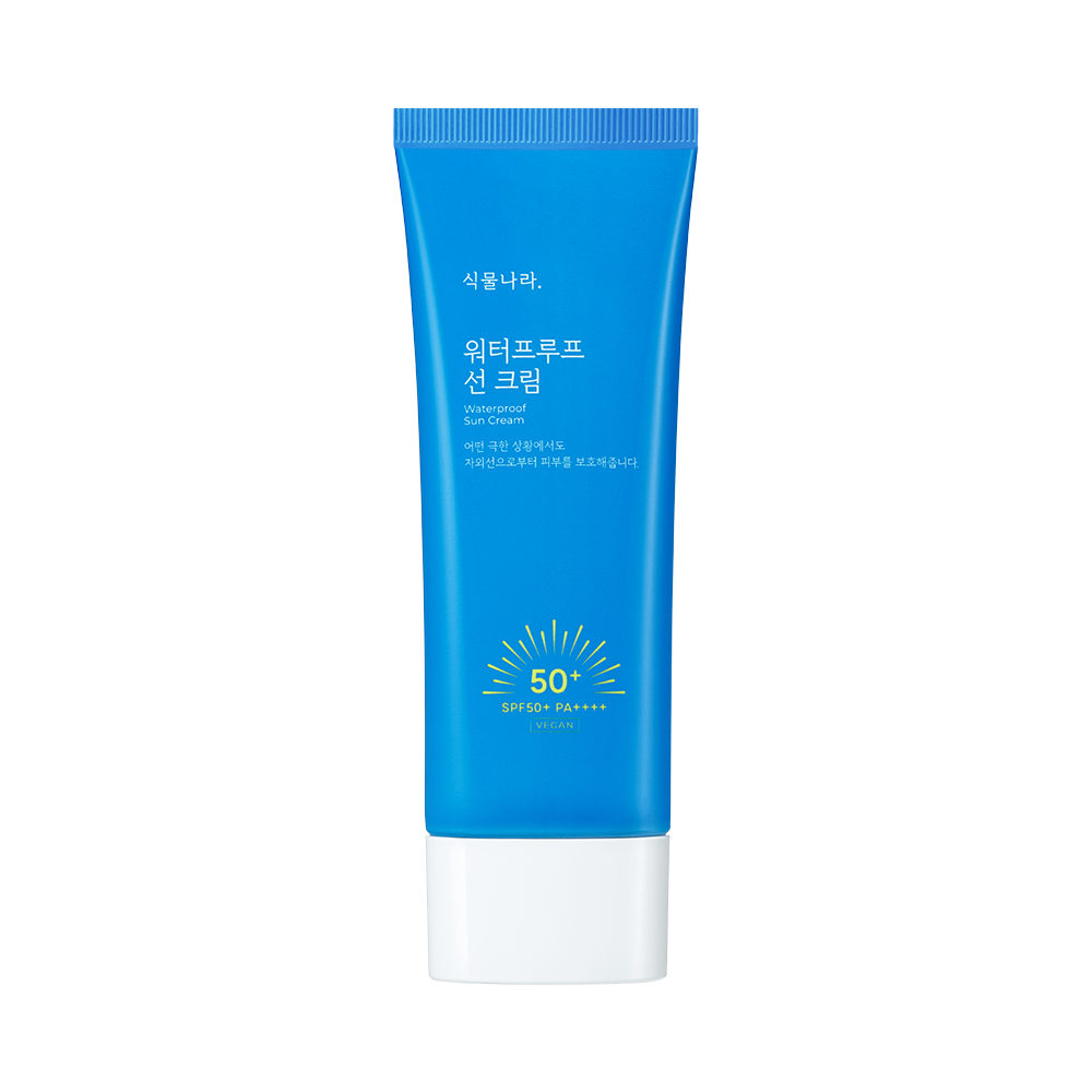 Tubo azul cielo con tapón blanco y la etiqueta «식물나라. 워터프루프 선 크림 Waterproof Sun Cream», un sol amarillo con «50+ SPF50+ PA++++» y una pequeña marca «VEGAN», sobre fondo blanco.