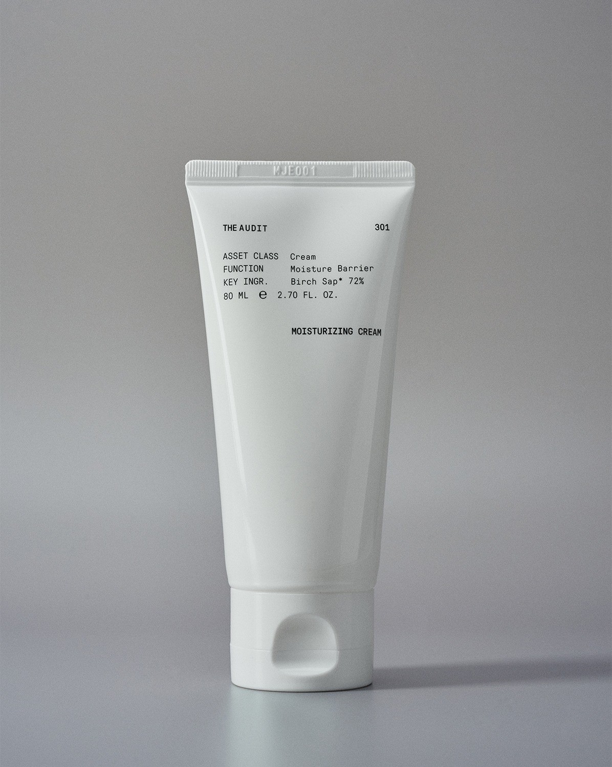 グレー背景にキャップを下にして立つ、THE AUDIT「301 Moisturizing Cream」80mlの白いチューブ。黒い文字でクリーム、Moisture Barrier、Birch Sap 72%と表示。